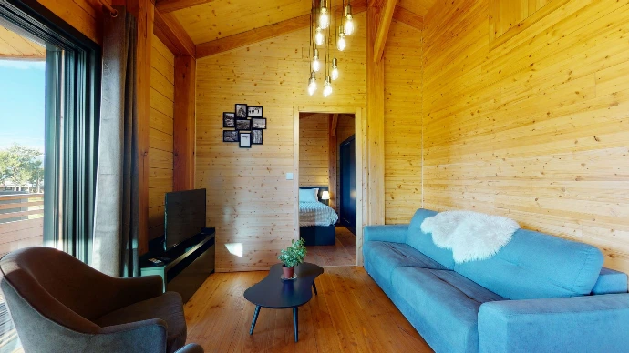 Zimmer mit blauer Bettwäsche in einem Holzchalet in Anzère