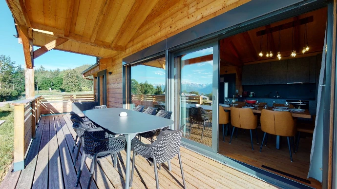 Überdachte Terrasse mit Tisch und Blick auf die Berge