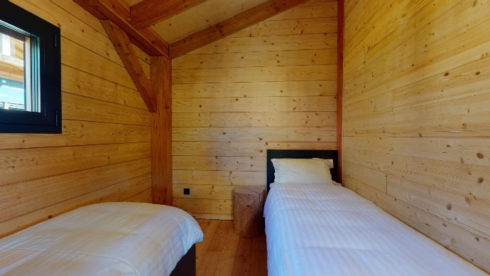Zimmer mit zwei Einzelbetten in einem Holzchalet in Anzère